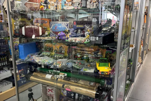 Figures, toys and a football among the collectibles in a tall glass case