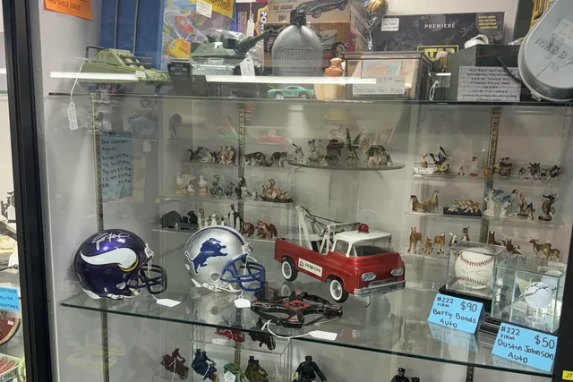 A glass case of model cars, helmets and small figurines