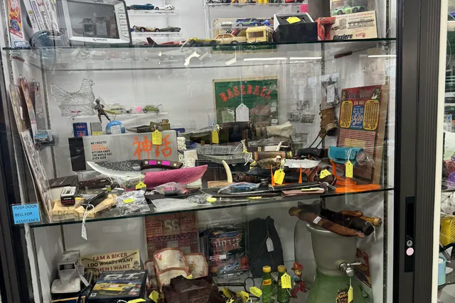 A glass case of small collectibles and tools