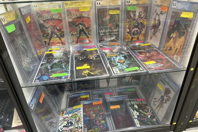 Graded Secret Wars and Black Widow comics in sealed cases under glass