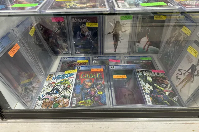 Graded comics in sealed cases inside a lit display counter