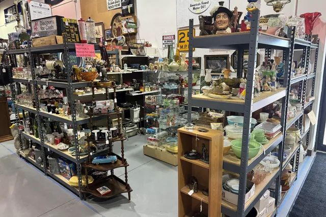 Shelves and cabinets of housewares and collectibles along an aisle