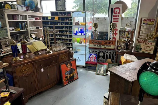 A booth by the windows with a cabinet, posters and a pegboard of small goods