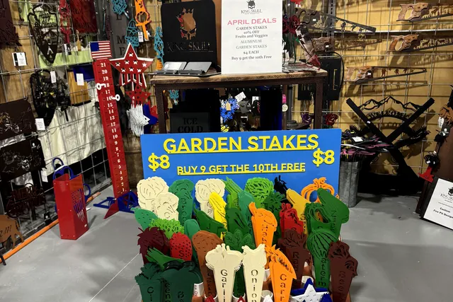 A booth of garden stakes and tools beside hanging displays