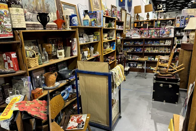 A booth of framed art, trophies and lamps around a rocking chair
