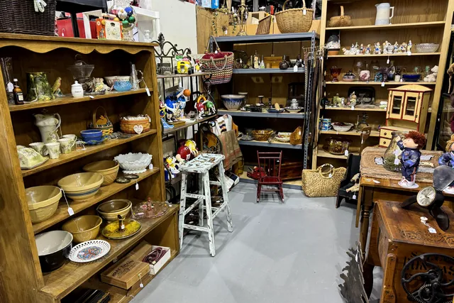 Wooden shelves of pottery bowls, pitchers and serving dishes