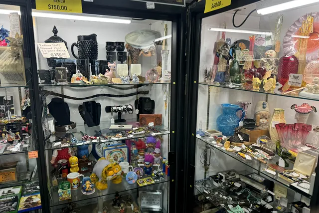 A glass case of colored glassware, perfume bottles and small jewelry