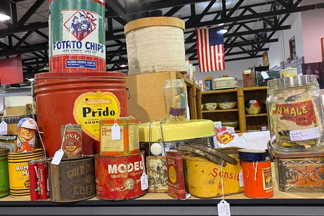 Vintage advertising tins for potato chips, tobacco and shortening lined up on a shelf